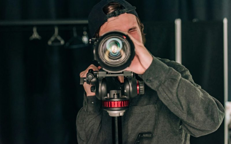 videographer-looking-through-camera-in-photo-studio